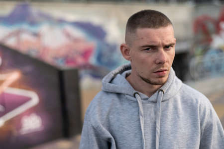 A bully guy in a light sports jacket with a hood