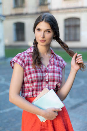 Girl student in red skirt and plaid shirtの写真素材