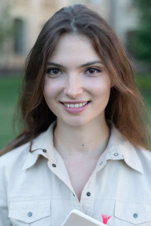 Young beautiful girl student in shirt by day