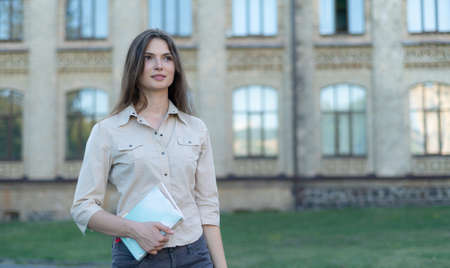 Young beautiful girl student in shirt by dayの写真素材