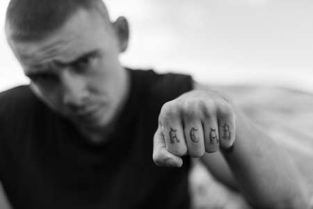 ACAB tattoo on the arm of a bully man. Black and white photoの写真素材