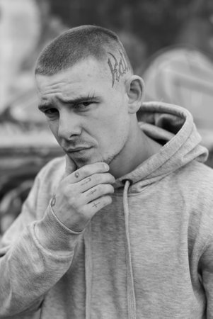 A bully guy in a light sports jacket with a hood. Black and white photo. BWの写真素材