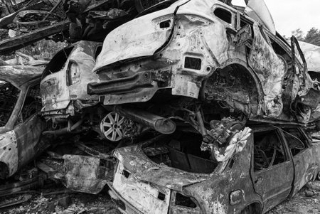 Dump of war-destroyed cars in Ukraine, black and white photo