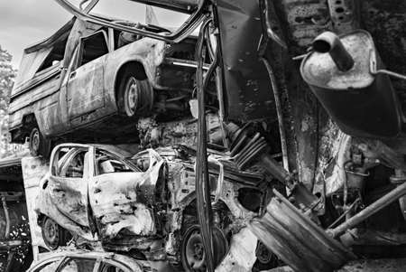 Dump of war-destroyed cars in Ukraine, black and white photo