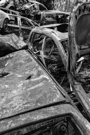 Black and white photo of the war in Ukraine - destroyed cars in Bucha district