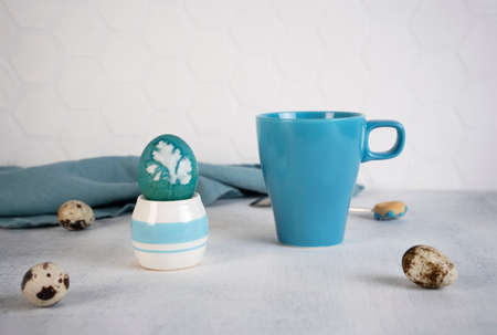 Blue Easter egg with blue mug. Natural coloring Easter eggs with red cabbage in blue color. Parsley leaf design.の写真素材