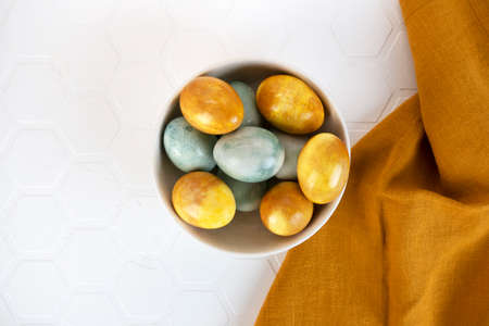 Yellow Easter eggs in a bowl. Natural coloring Easter eggs with turmeric powder in yellow color.の写真素材