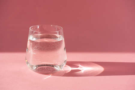 Glass of fresh pure water. Hard light, deep shadow.の写真素材