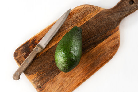 Fresh delicious avocado on a cutting board with a knife. Vegetarian food. Time for breakfast.の写真素材