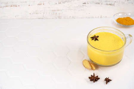 Golden milk. Star anise is in a glass of turmeric moon milk. Healthy drink. Copy space.の写真素材