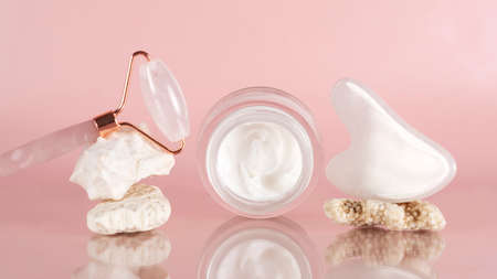 Face cream, gouache scraper and jade massage roller for face massage. Home facial skin care.の写真素材