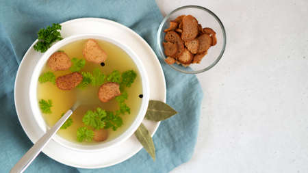 Homemade chicken bone broth with bay leaves and parsley. Health benefits.の写真素材