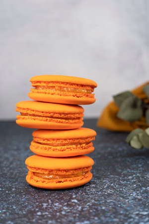 Orange macaroons. Delicious french cookies. Sweet dessert. Vertical orientation.の写真素材