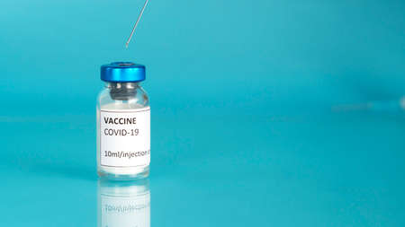 Coronavirus vaccine vial. Covid vaccination with vaccine bottle. Blue background. Banner with copy space.の写真素材