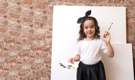 Talented girl artist with palette of colors and painting brush. Art school workshop. Copy space.の写真素材
