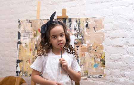 Talented little girl artist with painting brush. Art school workshop.の写真素材