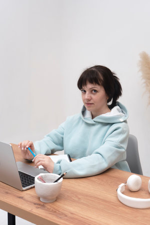 A young woman student studying online using a laptop. Distance remote e-learning.の写真素材