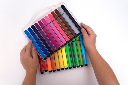 Kids hands hold a set of colored markers for drawing. Little artist art school.の写真素材