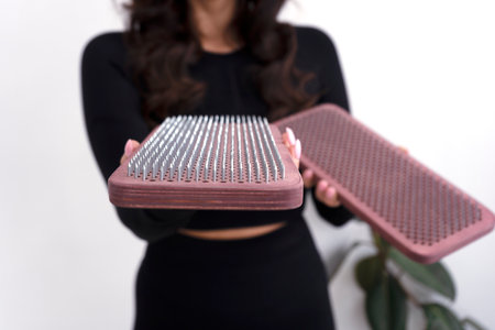 Female nail standing coach wearing black training suit holding sadhu board. Selective focus.の写真素材