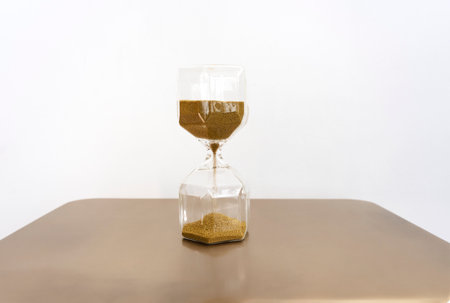 The hourglass or sandglass. Sand is pouring counting the time. Selective focus.の写真素材