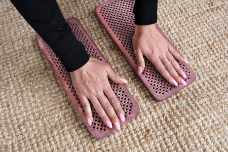 Yogi womans hands touch a sharp nail on a wooden sadhu board. Alternative medicine. Top view.の写真素材