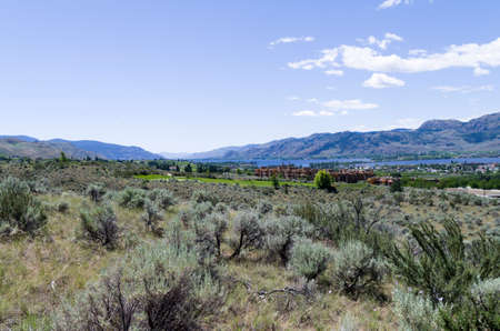Desert landscape with Spirit Ridge resort buildings and Lake Osoyoos in the backgroundの写真素材