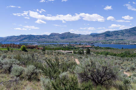 Desert landscape with Spirit Ridge resort buildings and Lake Osoyoos in the backgroundの写真素材
