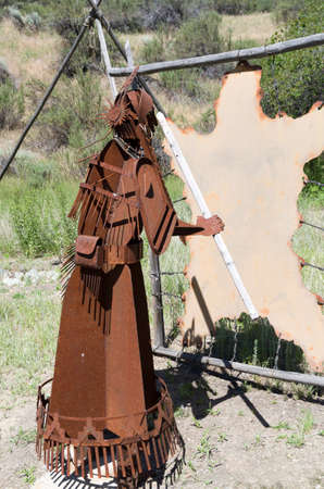 Metal sculpture of a woman tanning an animal hide.のeditorial素材