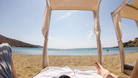 Man Relaxing on a Beach Bed on a Beautiful Sunny Day. Agios Romanos Tinos. Greece.