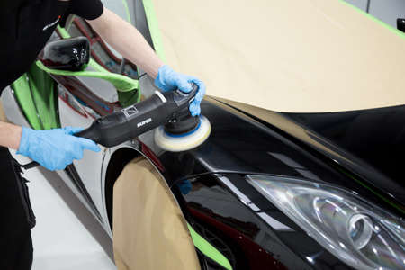 Detailer using a rotary machine on a sports car panelの写真素材
