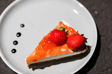 Close up of strawberry cheese cake slice on a plateの写真素材