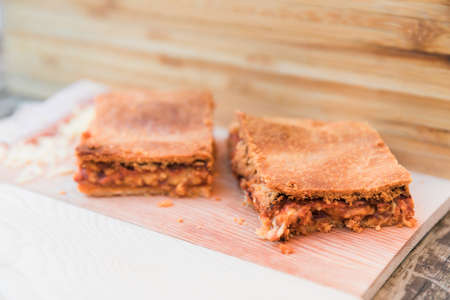 Slices of ham and cheese pastry on a wooden surfaceの写真素材