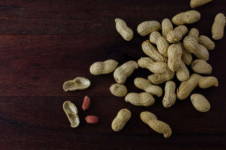 Peanuts in shells on dark wooden boardの写真素材