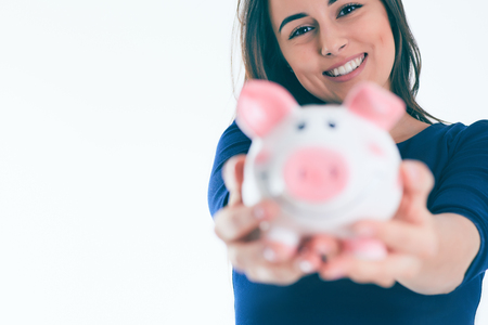 Surprised Beautiful chef woman holding a piggybank.の写真素材