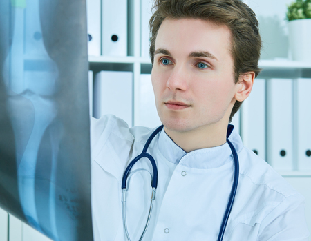 Close up of male Caucasian doctor holding x-ray or roentgen image.の写真素材