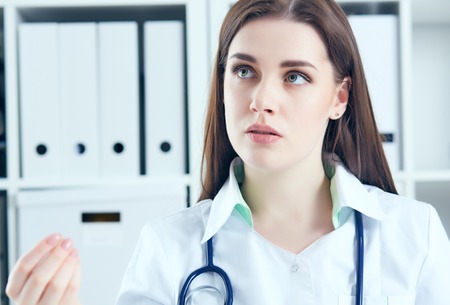 Young female doctor giving a consultation to a patient and explaining medical informations and diagnosisの写真素材