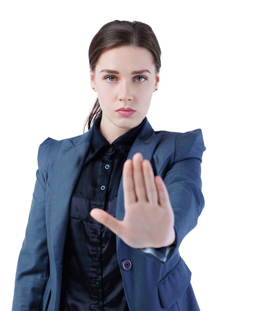 Serious Caucasian businesswoman making stop sign on white background, focus on business woman.の写真素材
