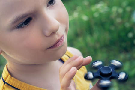 Young schoolboy holding popular fidget spinner toyの写真素材