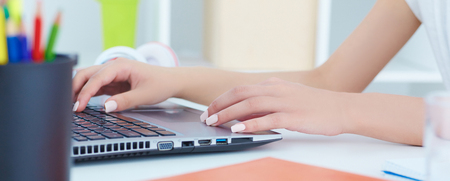 Close up of female hands typing on laptop keyboard. Hard office work concept.の写真素材