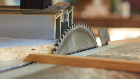 Close up electric saw to sawing wood board, solf focus.の写真素材