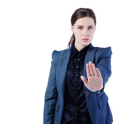 Serious Caucasian businesswoman making stop sign on white background, focus on business woman.の写真素材