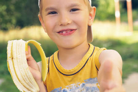 Healthy little boy eating banana.の写真素材