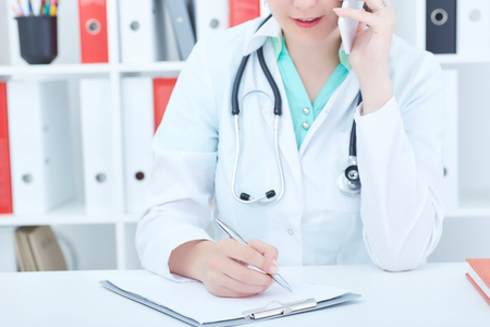 Portrait of a beautiful medical doctor talking on the phone.の写真素材