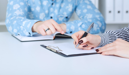 The employer forces the employee to write a letter of resignation. Just hands over the table.の写真素材