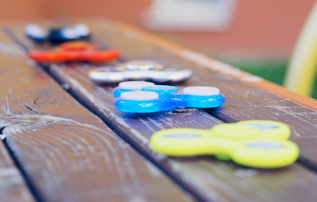 Spinners lying in a row. Stress relieving toy on wooden surface. Selective focus.の写真素材