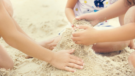 Group of little children build a sand tower, hands closeupの写真素材