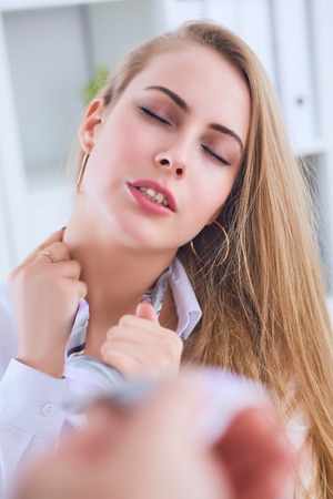 Boss hand pulls pretty secretary the necktie on a office background. Sexual harassment concept.の写真素材