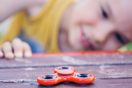 Young boy play with fidget spinner stress relieving toyの写真素材