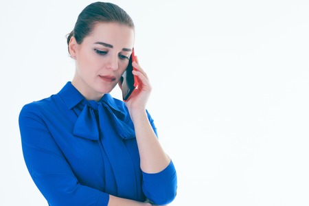 Sad real estate female agent talking on mobile phone. Isolated on white.の写真素材