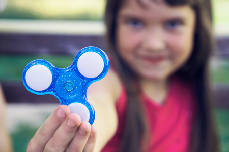 Young girl play with fidget spinner stress relieving toyの写真素材